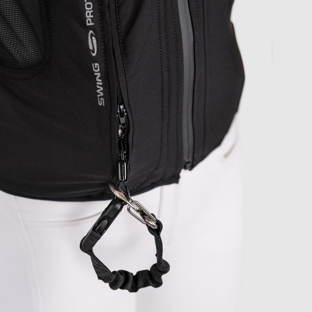 Close-up of a black backpack zipper with a knotted elastic strap and metal clip.