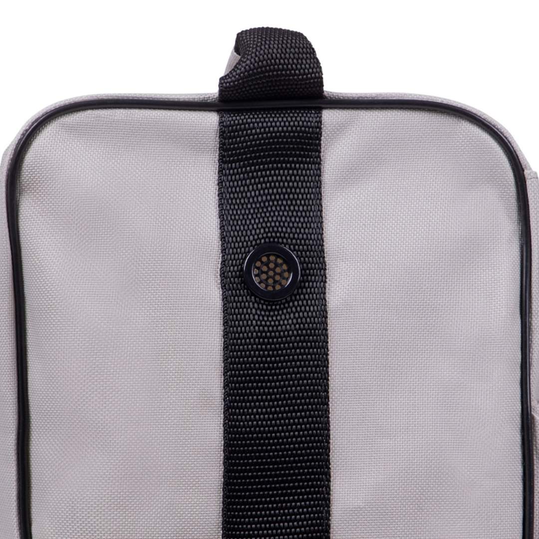 Gray fabric travel bag close-up showing a black strap running vertically with a round button in the center of the strap.