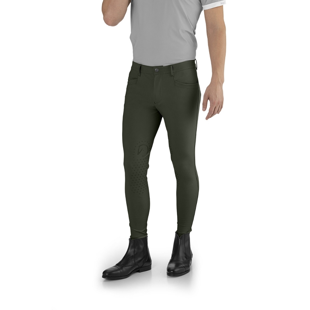 Men's olive green riding pants with grip dots on thighs, paired with a gray shirt and black boots (front view).