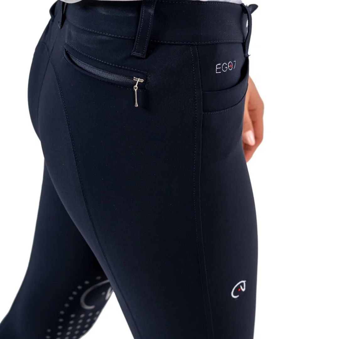 Navy riding breeches with a back zip pocket and brand logo EGO7 on the back pocket area, close-up view of hips and thigh.